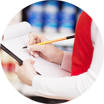 メモ帳に在庫や商品情報を記録しているスタッフ