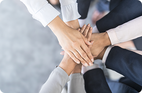 複数人で手を重ねてチームワークを表現している様子